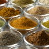 Glass bowls with variation of colorful powder herbs close up full frame as background