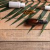 Cosmetic with green leaf on wooden background