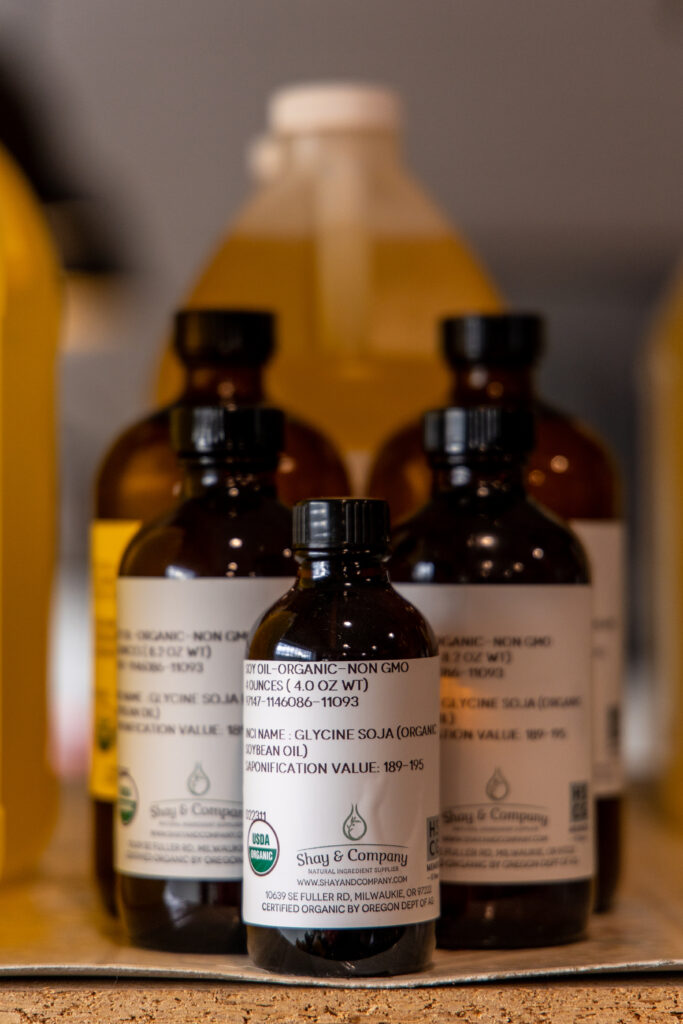 A shelf of Shay & Company wholesale ingredient bottles