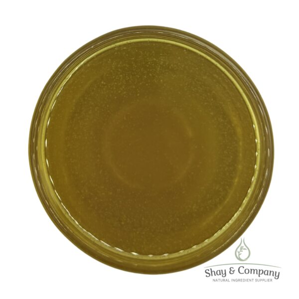 Golden yellow oil in clear glass jar with Shay & Company natural ingredient supplier logo.