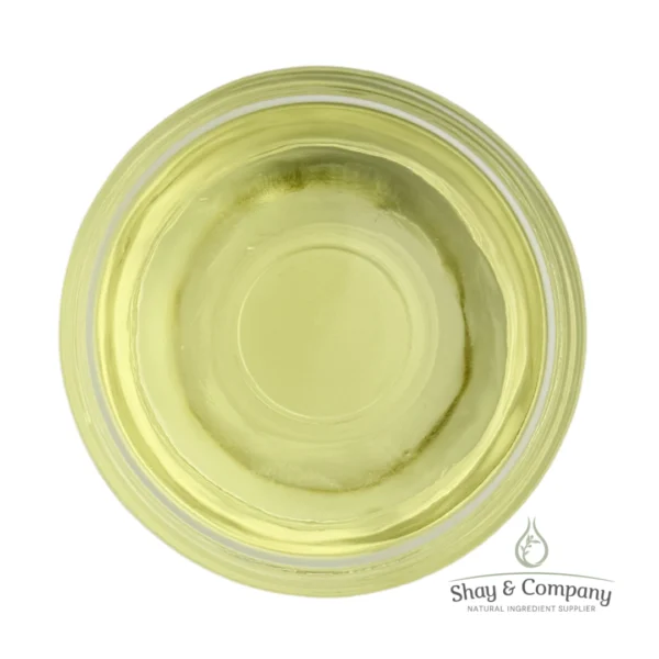 Top-down view of pale yellow natural oil in a clear glass dish with Shay & Company logo.