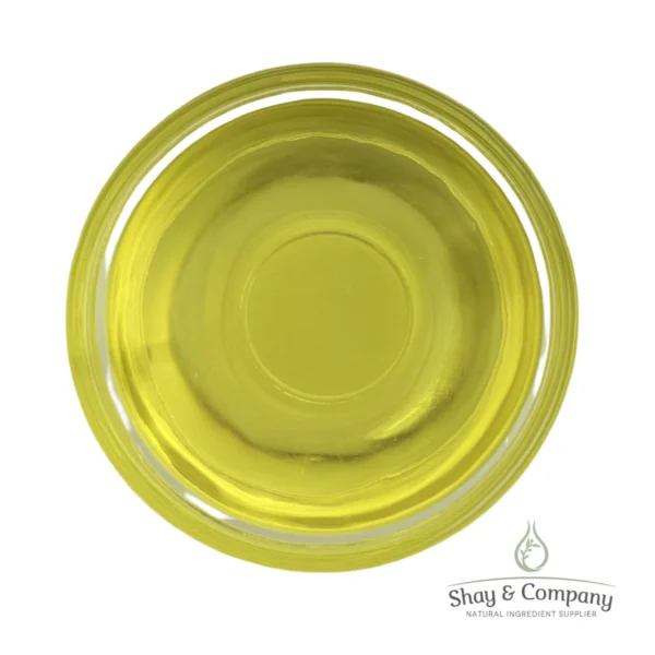Top-down view of yellow carrier oil in a clear glass dish with Shay & Company logo.