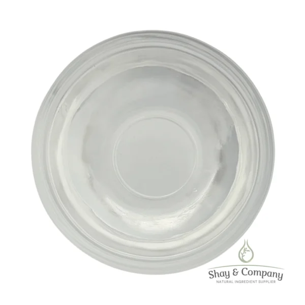 Clear glass bowl viewed from above containing transparent liquid, Shay & Company natural ingredient supplier logo.