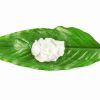 Shea butter on green leaf on white background